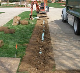 A drainage pipe being laid in dirt