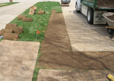 Sod being installed next to a drive way
